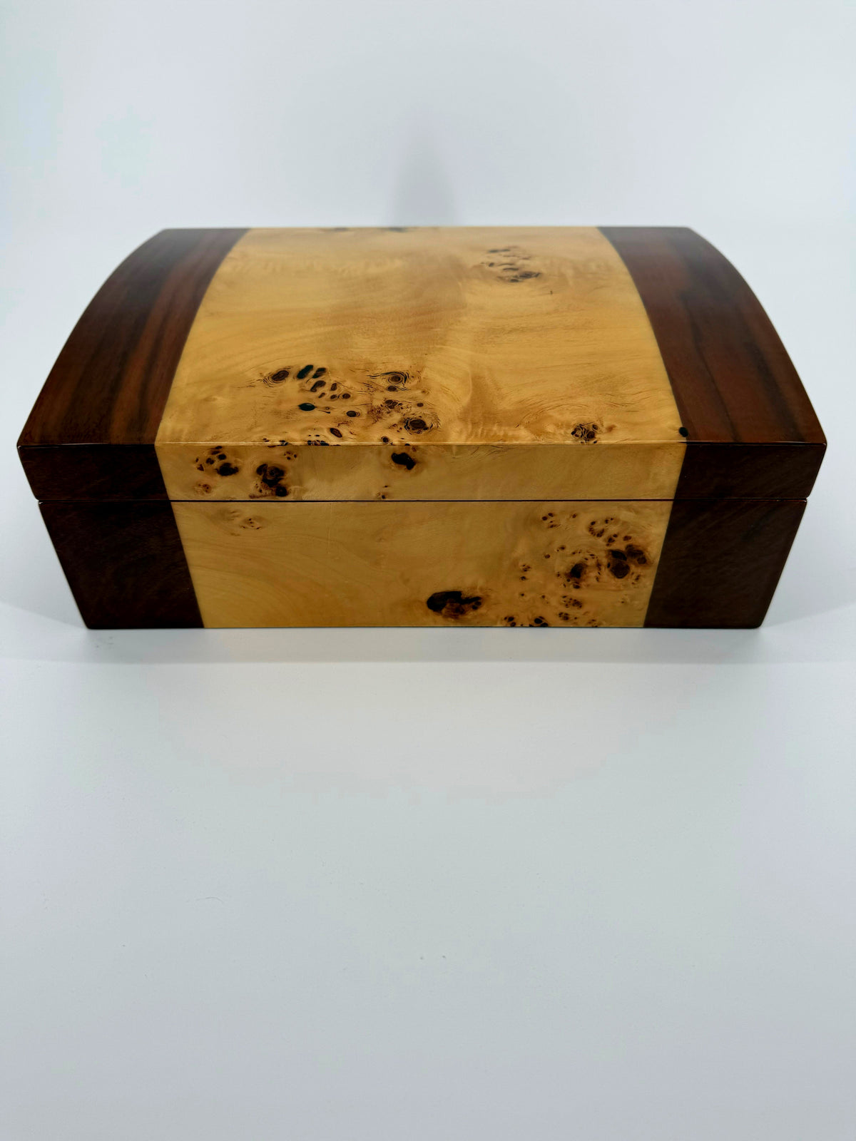High-gloss wood desktop cigar humidor with burl veneer — closed, front view on a white background