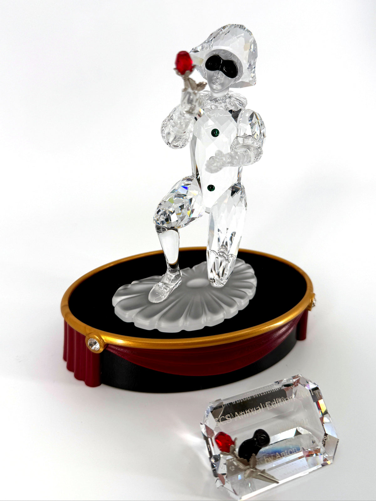 Swarovski SCS 2001 Harlequin Masquerade crystal figurine — the figurine on its oval stage base with the crystal title block in front