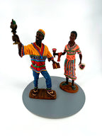The Kwanzaa pair from the front — his golden-yellow and red tunic, her coral patterned dress