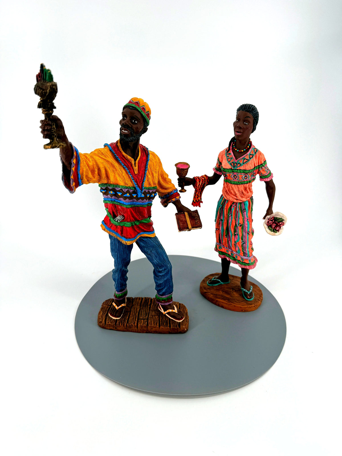 The Kwanzaa pair from the front — his golden-yellow and red tunic, her coral patterned dress
