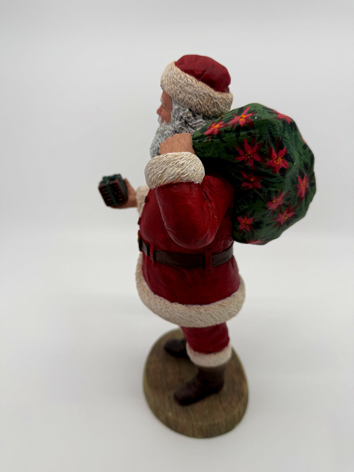 Vintage 1994 Duncan Royale Santa's Gift figurine – three-quarter back view showing the poinsettia gift sack