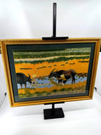 Signed Vietnamese hand-embroidered textile art — water buffalo in rice terraces — the framed piece on its stand, angled view