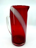 Vintage ruby red glass pitcher with white swirl, 10.5 inch — front view with the clear handle at left