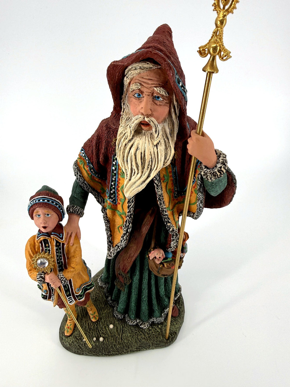 Close-up — hand-painted face, long white beard, and the child's star-topped staff