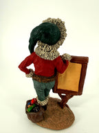 Duncan Royale History of Santa Claus Signature Piece - back view showing the plain back of the sign, the toy sack with colorful gifts and the green cap from behind