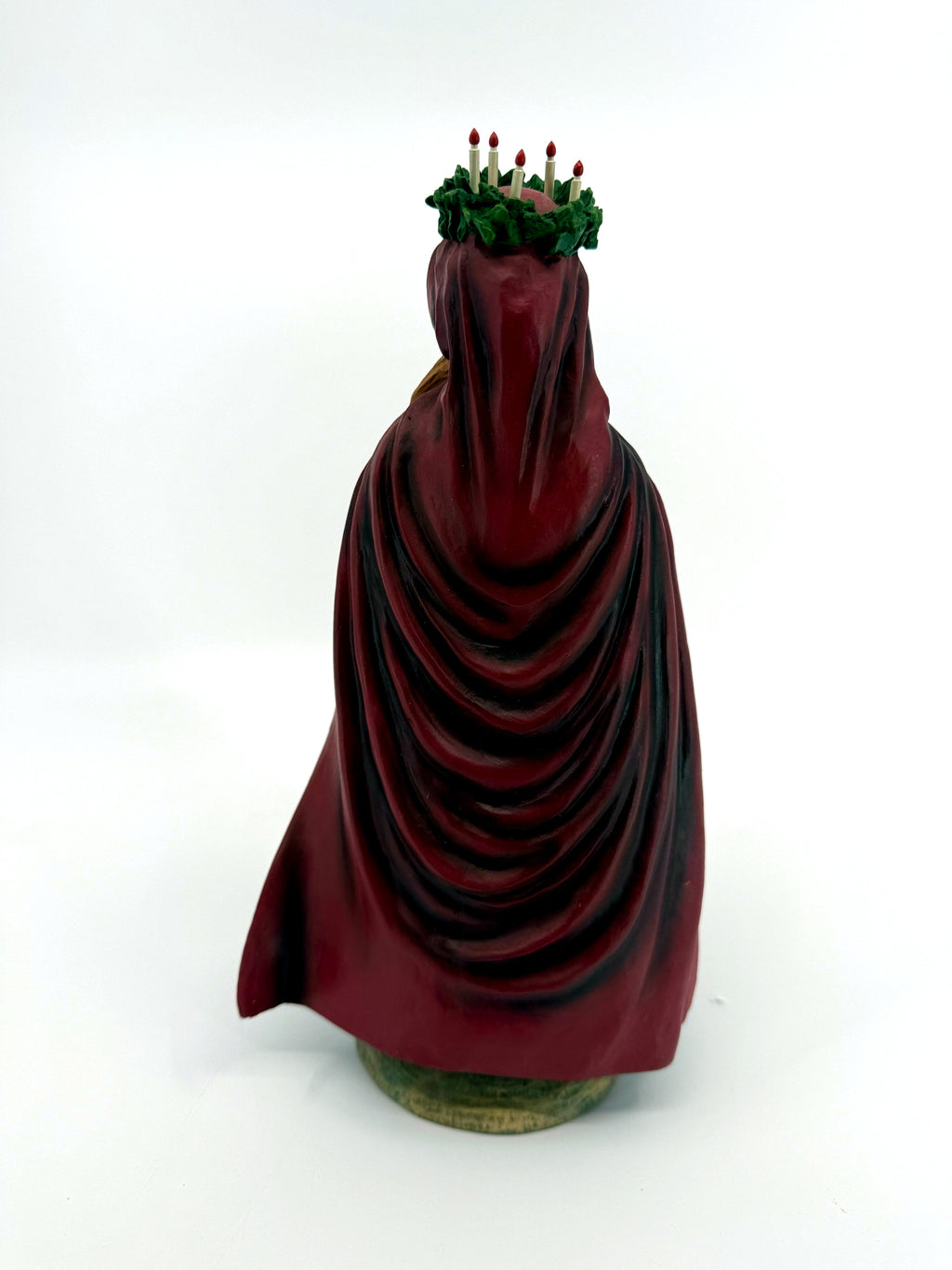 Back view — draped burgundy cloak, five candles in the crown