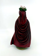 Back view — draped burgundy cloak, five candles in the crown