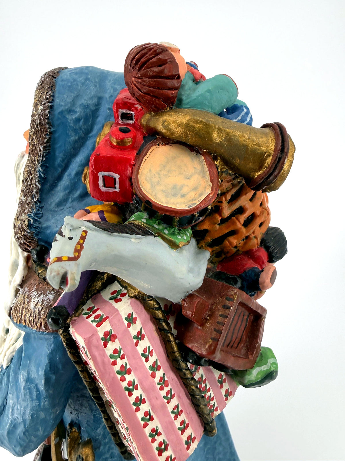 Close-up of the toy pack — rocking horse, drum, red toy train, dolls and wrapped gifts