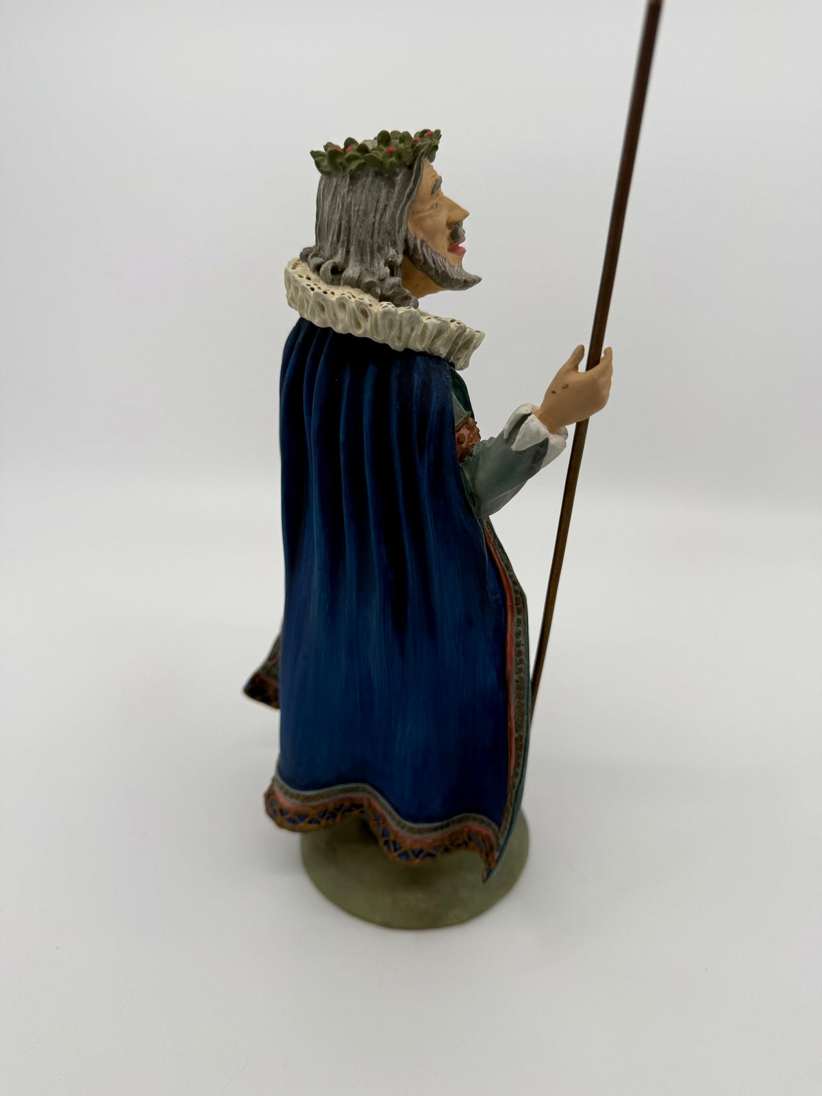 Vintage 1985 Duncan Royale Sir Christmas figurine – side profile view with staff: silver-gray hair, curled mustache and pointed beard, holly wreath