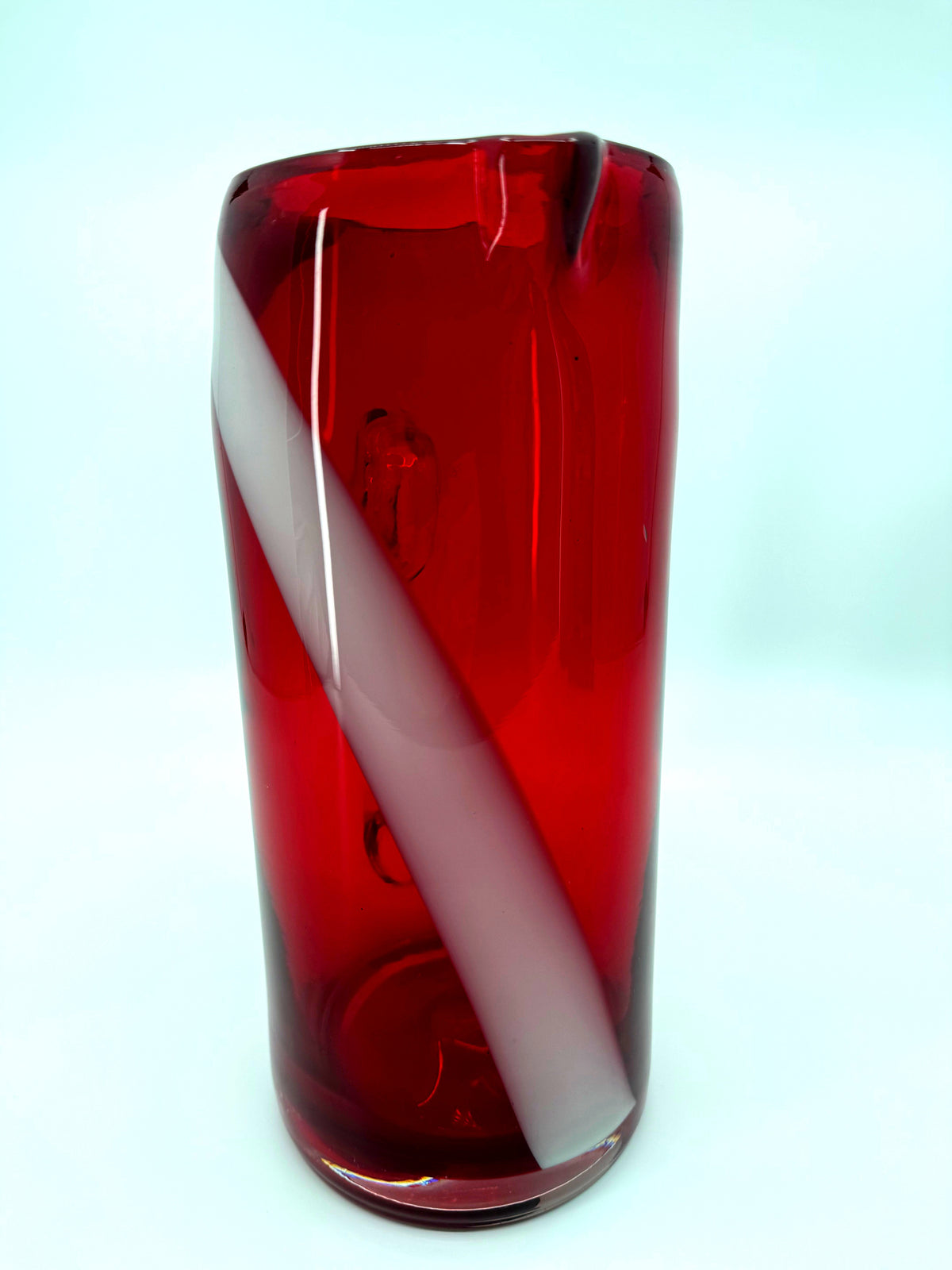 Vintage ruby red glass pitcher with white swirl, 10.5 inch — front view, handle hidden behind the body