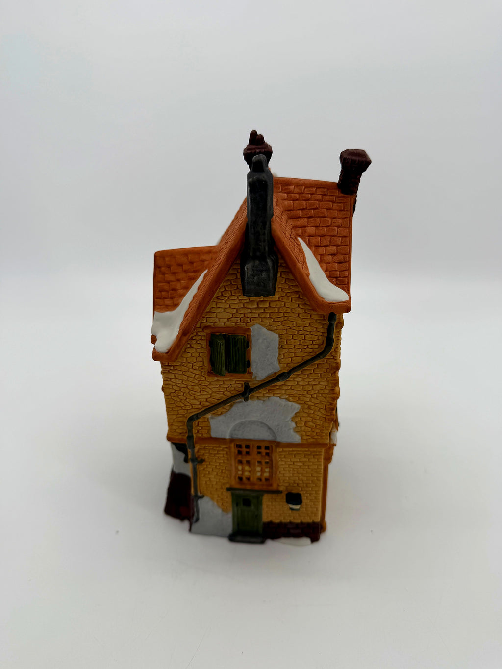 Brick side view with downspout, windows and snow-covered roof edge