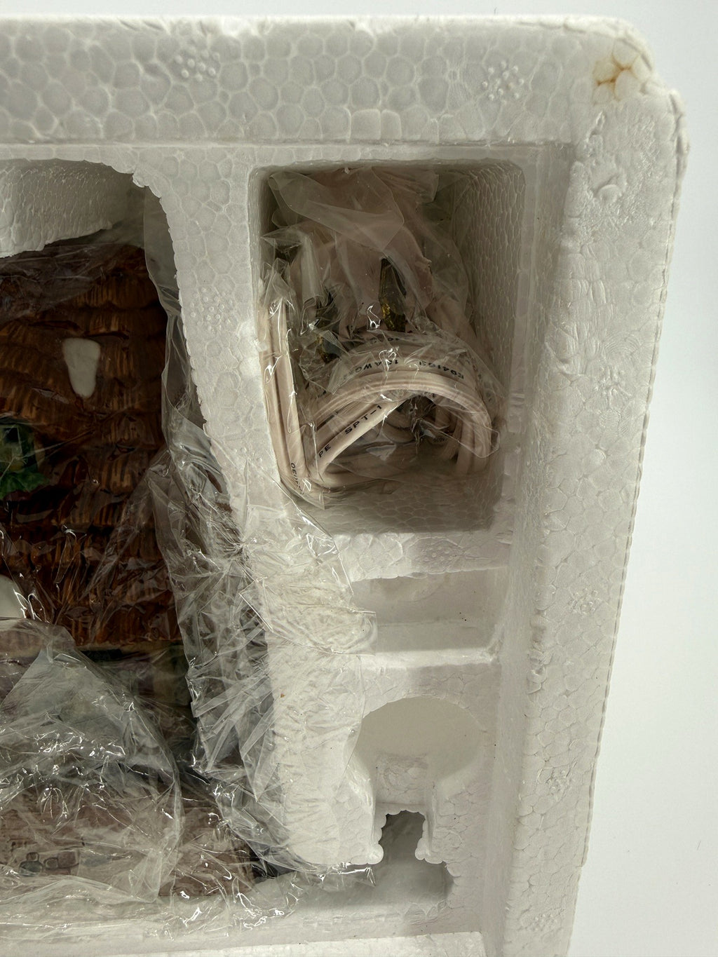 Department 56 Dickens' Village The Christmas Carol Cottage #58339 — packaging compartment with the wrapped light cord