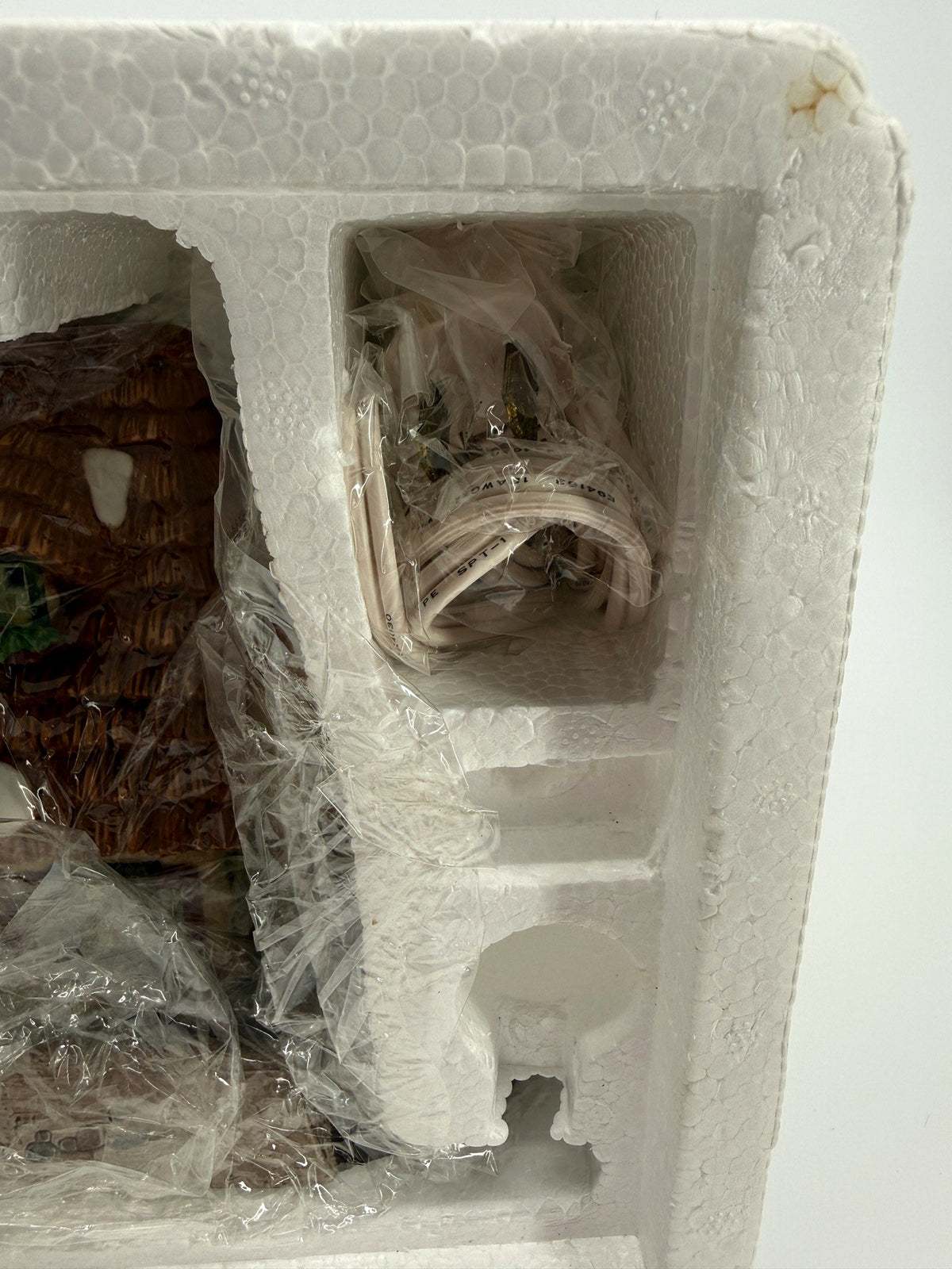 Department 56 Dickens' Village The Christmas Carol Cottage #58339 — packaging compartment with the wrapped light cord