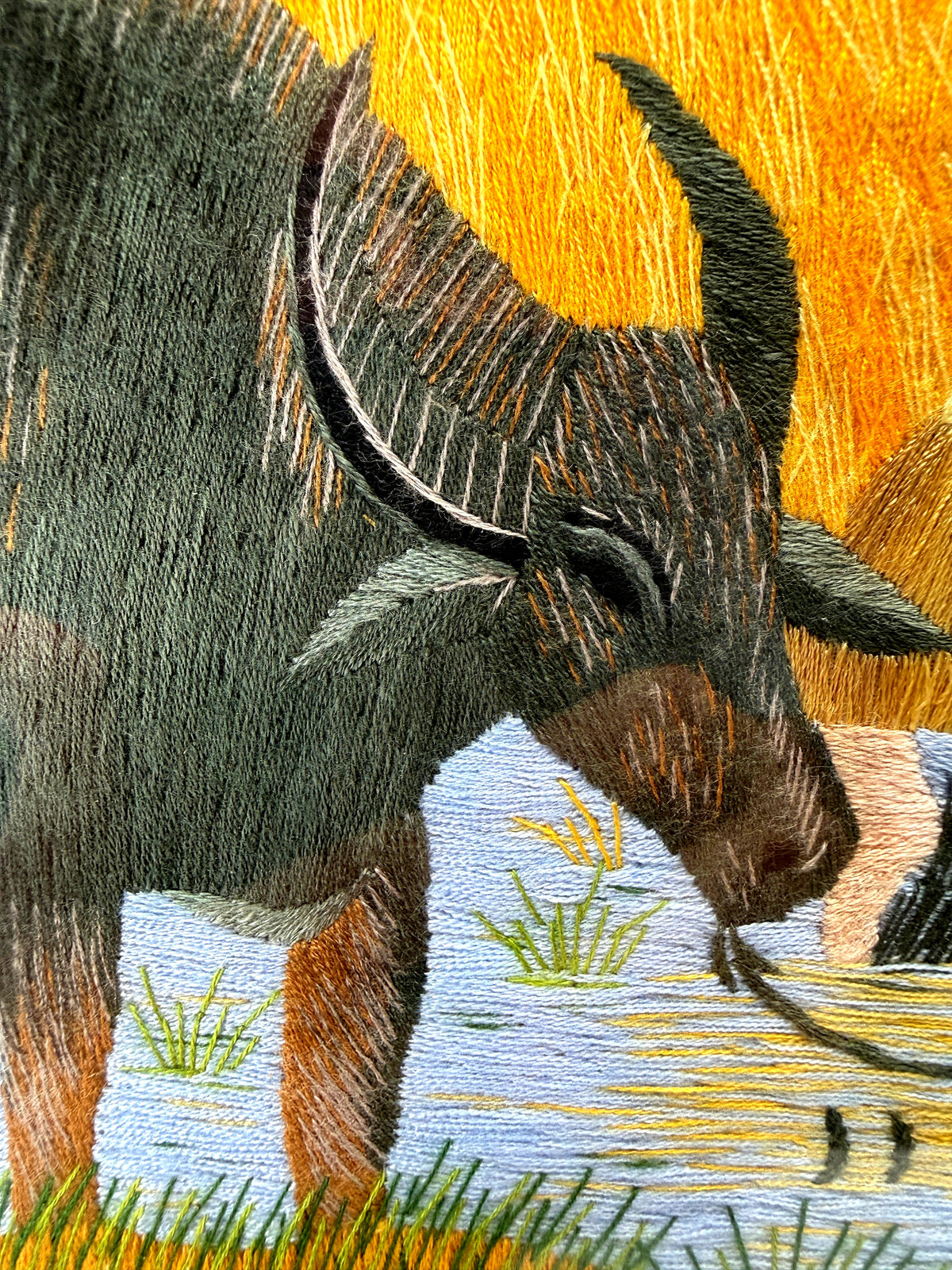 Signed Vietnamese hand-embroidered textile art — water buffalo in rice terraces — close-up of a buffalo's head and horns, stitch detail