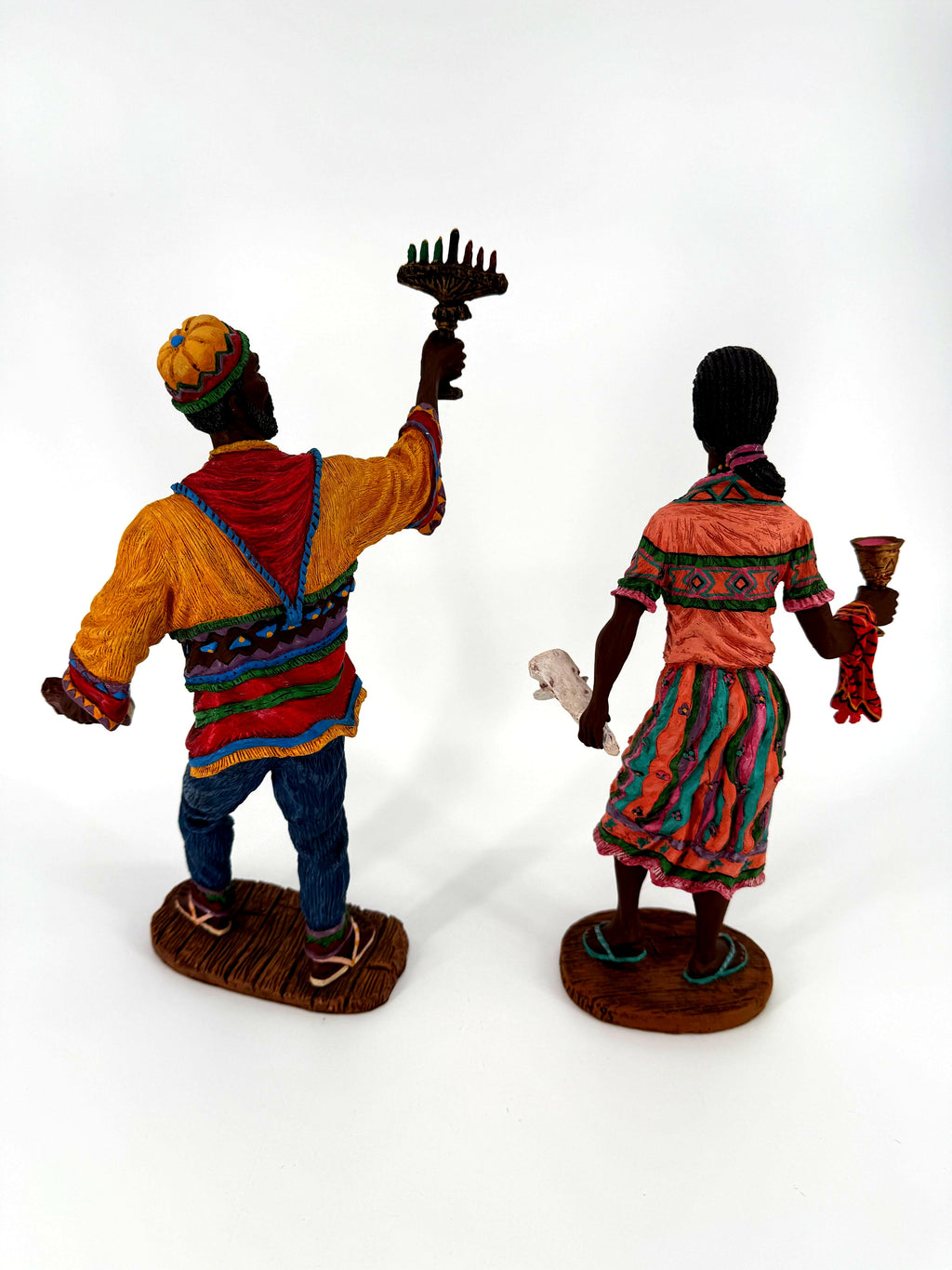 The pair from behind — the kinara’s seven candles visible over his raised hand