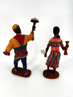 The pair from behind — the kinara’s seven candles visible over his raised hand