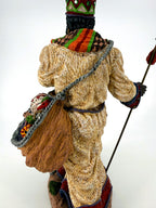 Back three-quarter view — shoulder sack filled with a patterned drum and gifts, cream robe texture