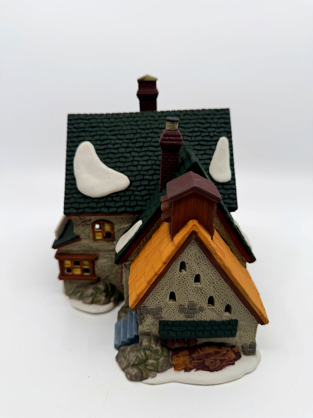 Rear gable view with louvered vents, stonework and wood pile detail