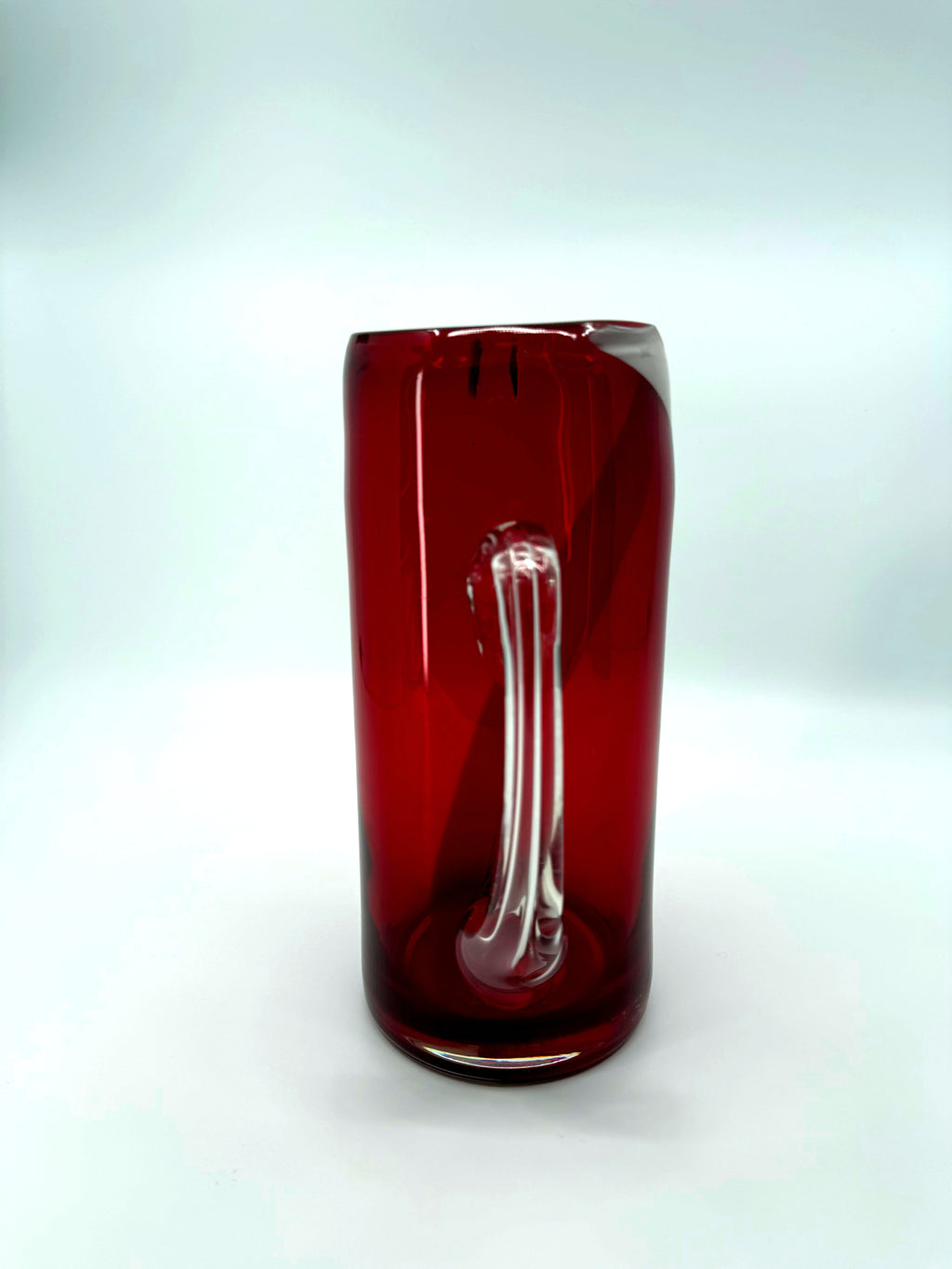 Vintage ruby red glass pitcher with white swirl, 10.5 inch — back view with the clear handle centred
