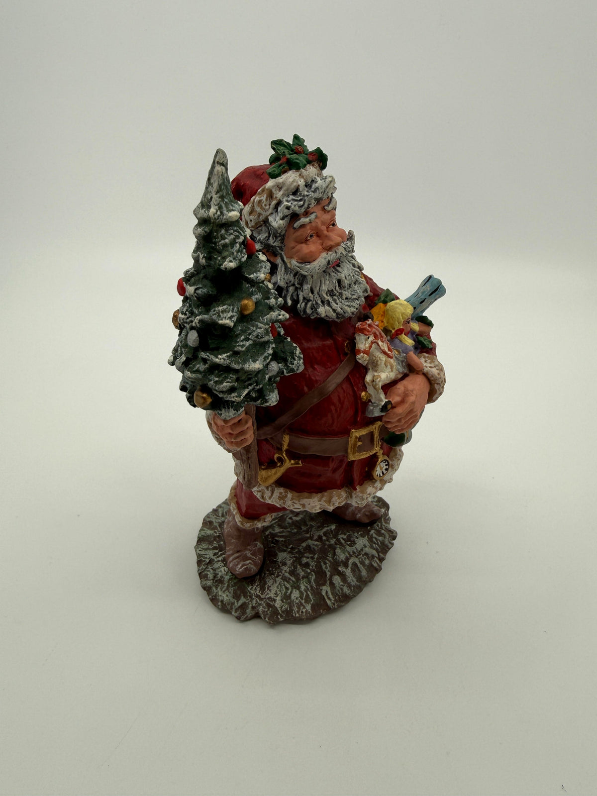 Vintage 1991 Duncan Royale Today's Nast Santa figurine – front-side view: rocking horse, doll and toy train carried in his arm, pocket watch at his belt