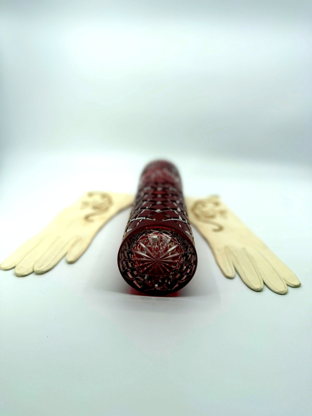 Vintage ruby red cut-to-clear glass vase, 12 inch — the vase lying down, close view of the cut base