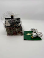 The building in protective wrap, with the new replacement light cord and original Heritage Village booklet