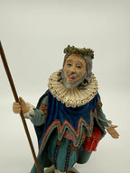 Vintage 1985 Duncan Royale Sir Christmas figurine – upper front view with staff: lace ruff with gold eyelet dots, scalloped cape trim edged in pink, pink sash belt