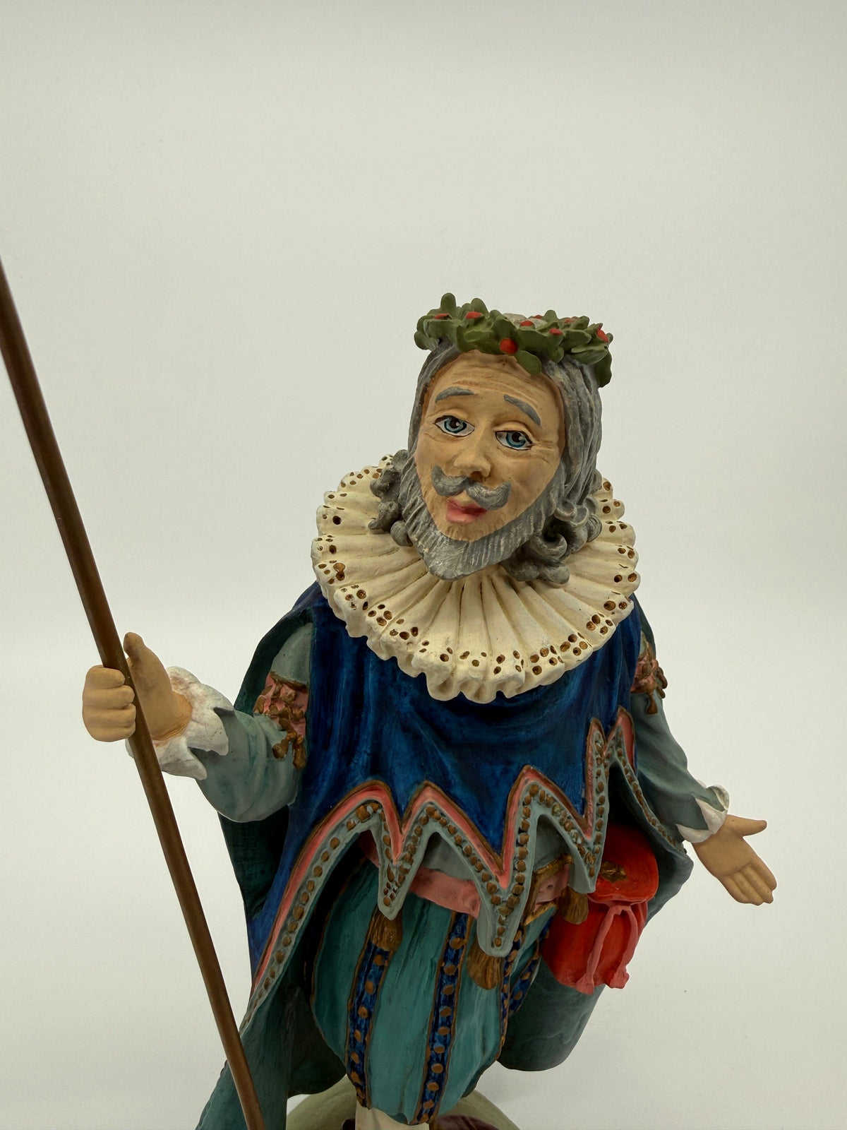 Vintage 1985 Duncan Royale Sir Christmas figurine – upper front view with staff: lace ruff with gold eyelet dots, scalloped cape trim edged in pink, pink sash belt