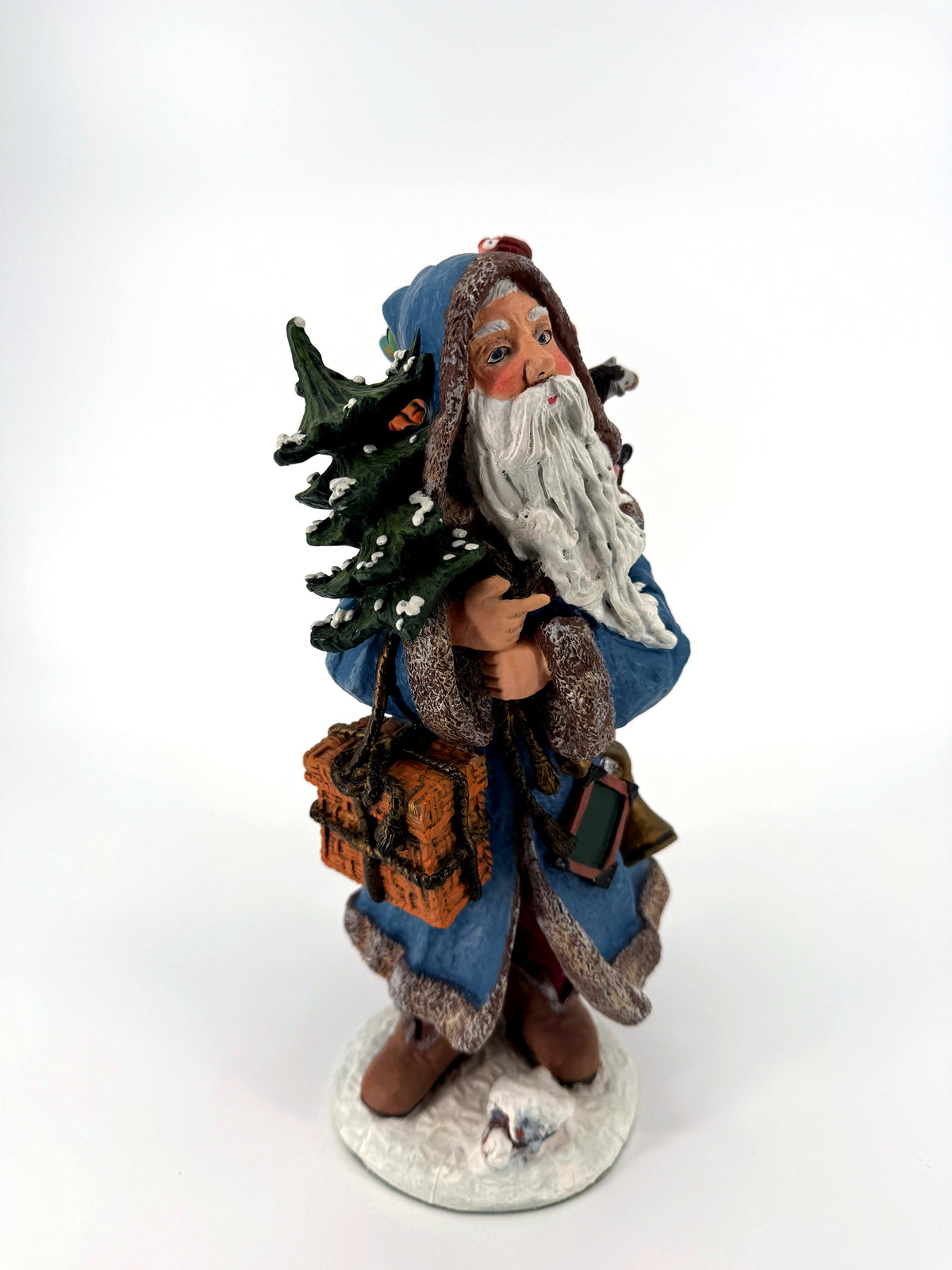 Winter Santa front view from his left — fur-trimmed hood, flowing white beard and snow-dusted tree