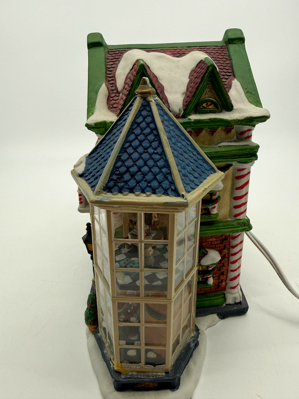 Side view of the glass bay tower on the Child's Wonder Candy Shop, with miniature interior scenes behind the panes