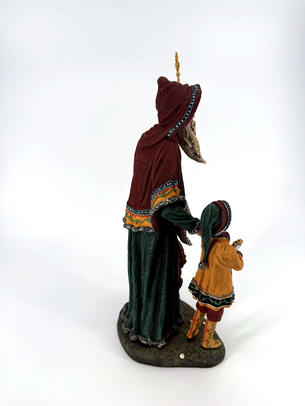 Right side view — the child from behind in his long green cap, Star Man's hooded profile