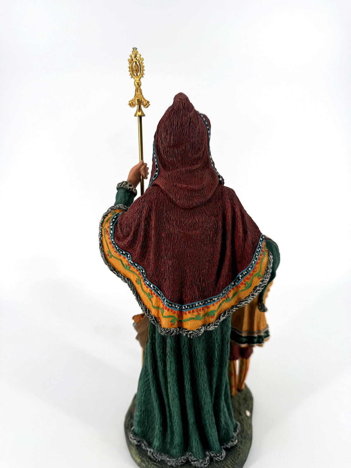 Back view — burgundy hooded cloak with golden ochre painted border over the green robe