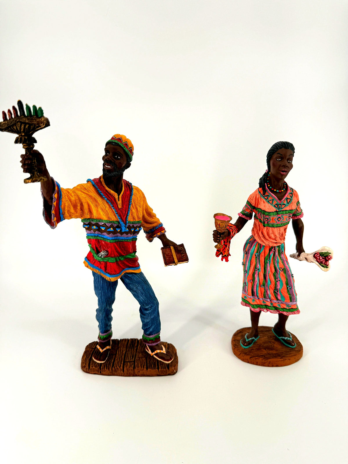 The Kwanzaa pair standing apart, front view — full figures with kinara, book, unity cup and bouquet