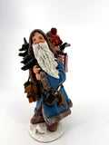 Duncan Royale Winter Santa 1993 figurine, front view — winter-blue fur-trimmed coat, snow-dusted Christmas tree and a pack overflowing with toys