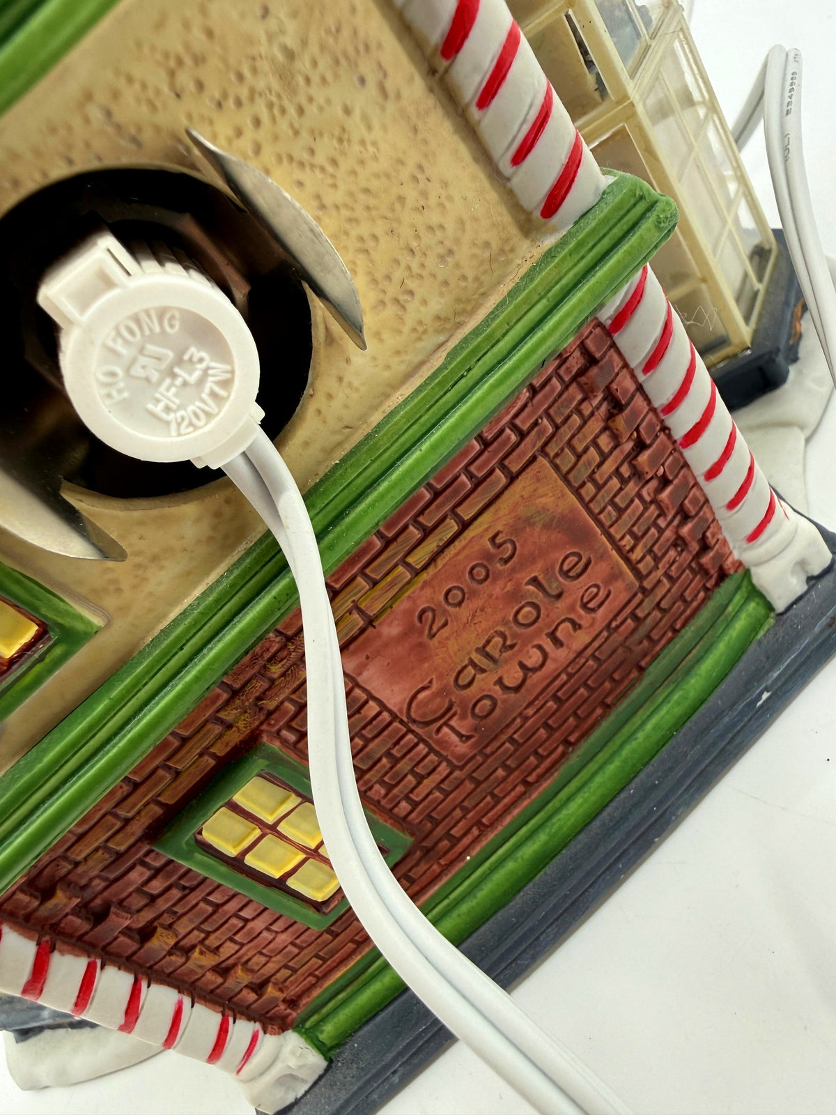 Close-up of the back of the building — C7 socket, cord, and the 2005 Carole Towne emboss on the brick panel