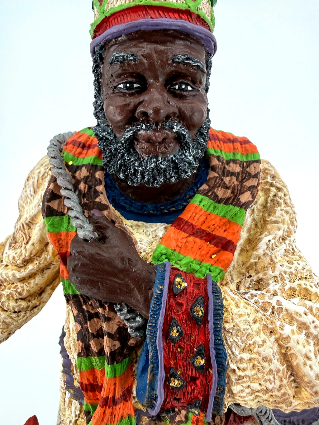 Face close-up — hand-painted features, gray-flecked beard and jeweled crown