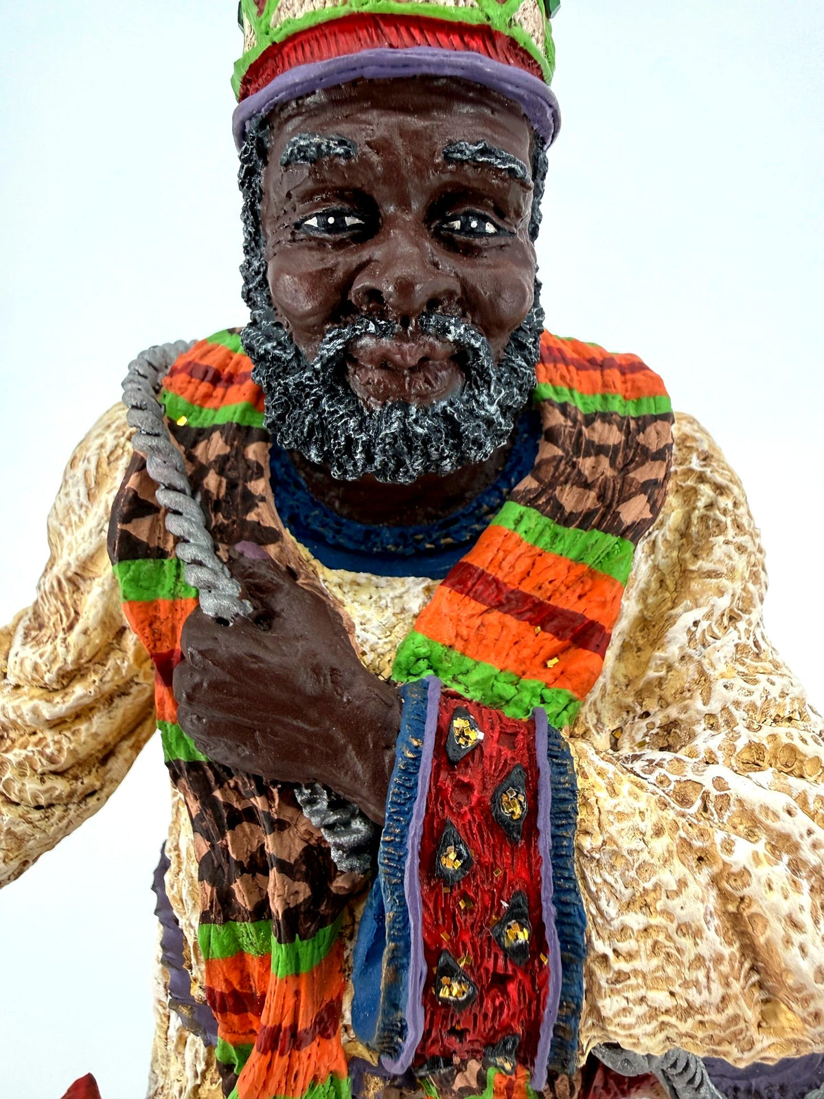 Face close-up — hand-painted features, gray-flecked beard and jeweled crown