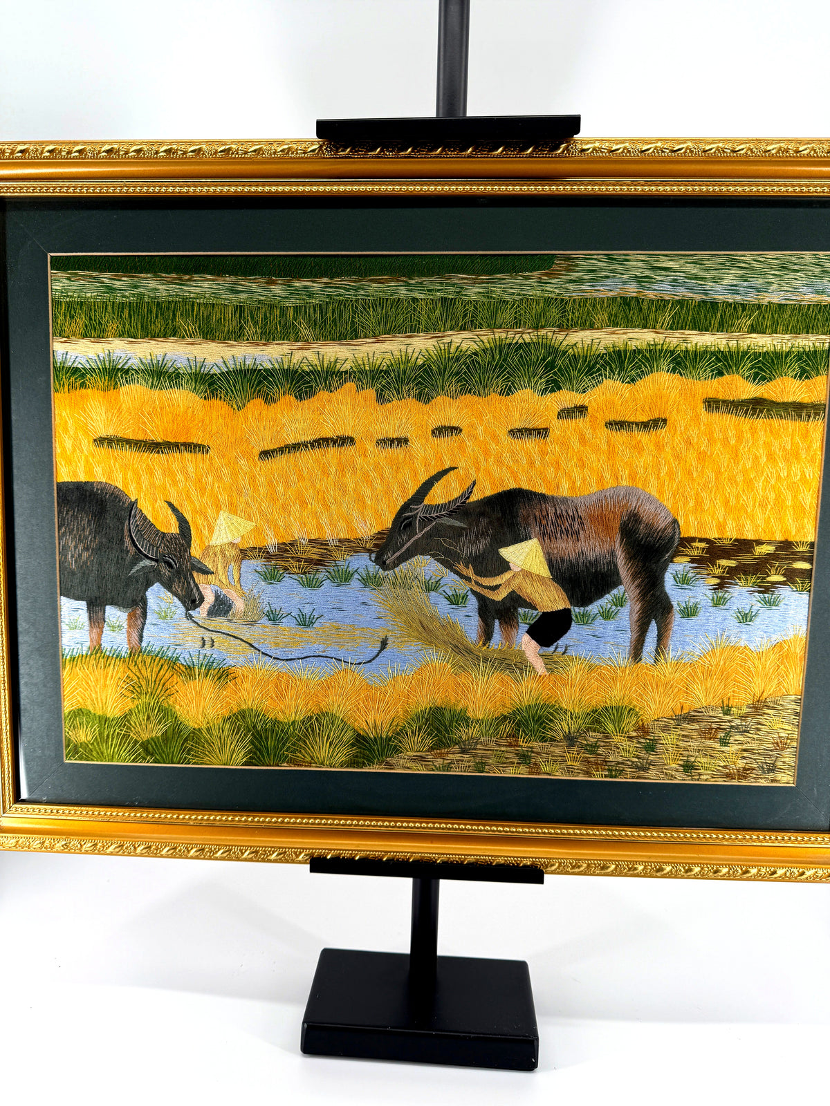 Signed Vietnamese hand-embroidered textile art — water buffalo in rice terraces — the framed piece centred on its stand