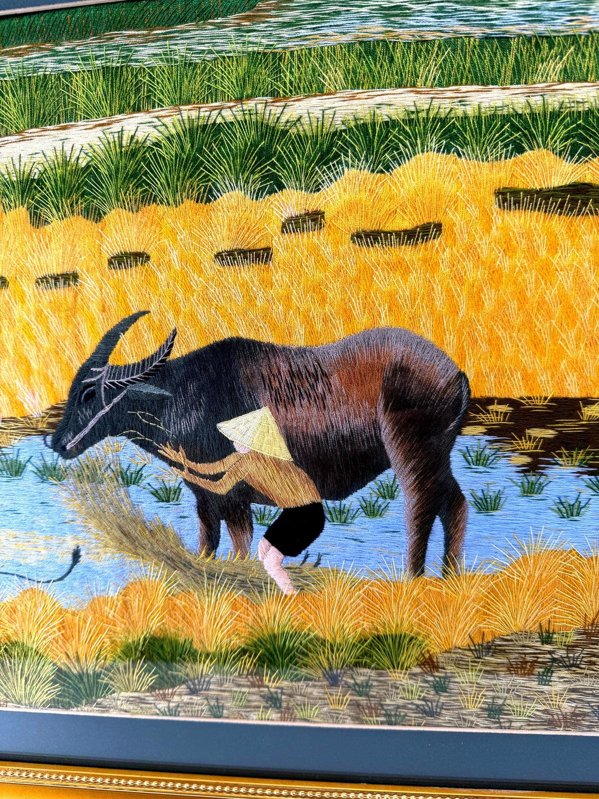 Signed Vietnamese hand-embroidered textile art — water buffalo in rice terraces — detail of the left buffalo, vertical view