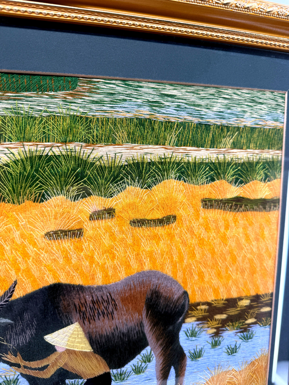 Signed Vietnamese hand-embroidered textile art — water buffalo in rice terraces — detail of the top centre — terraces with buffalo heads below