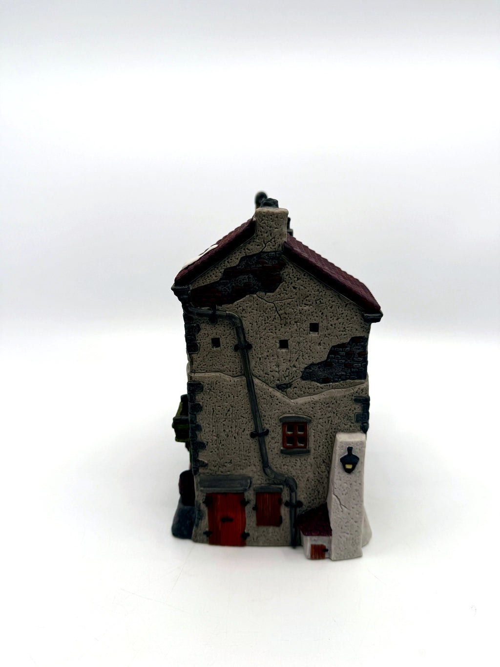 Right end: stone gable end with wooden doors, drainpipe and lantern