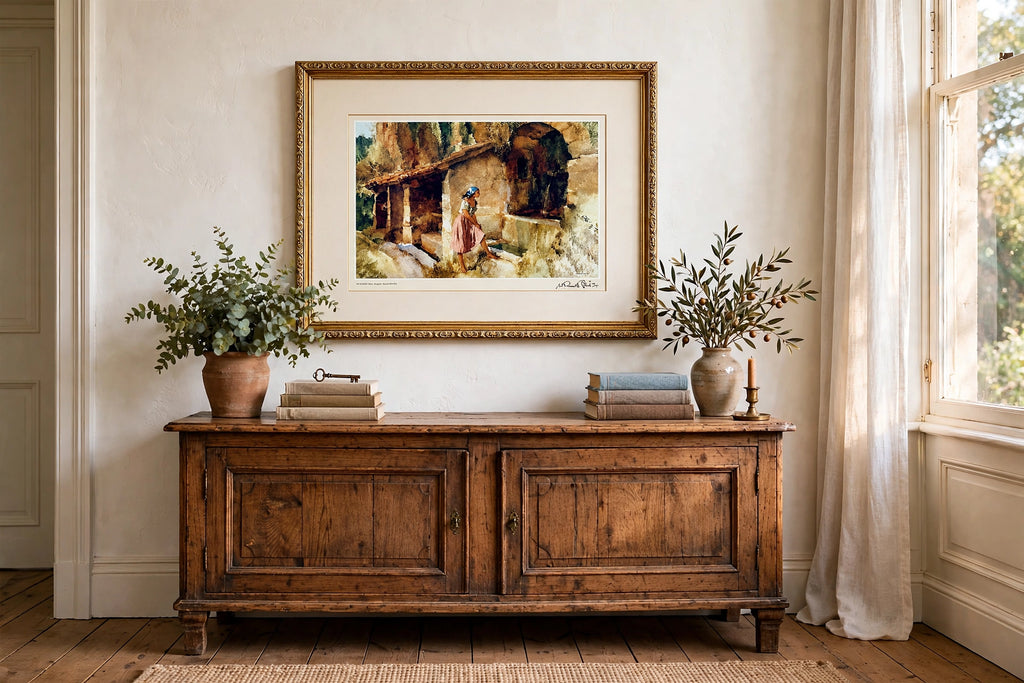 Styled lifestyle photo — the framed Flint Wishing Well print above an antique wooden sideboard in a vintage living room (display inspiration)