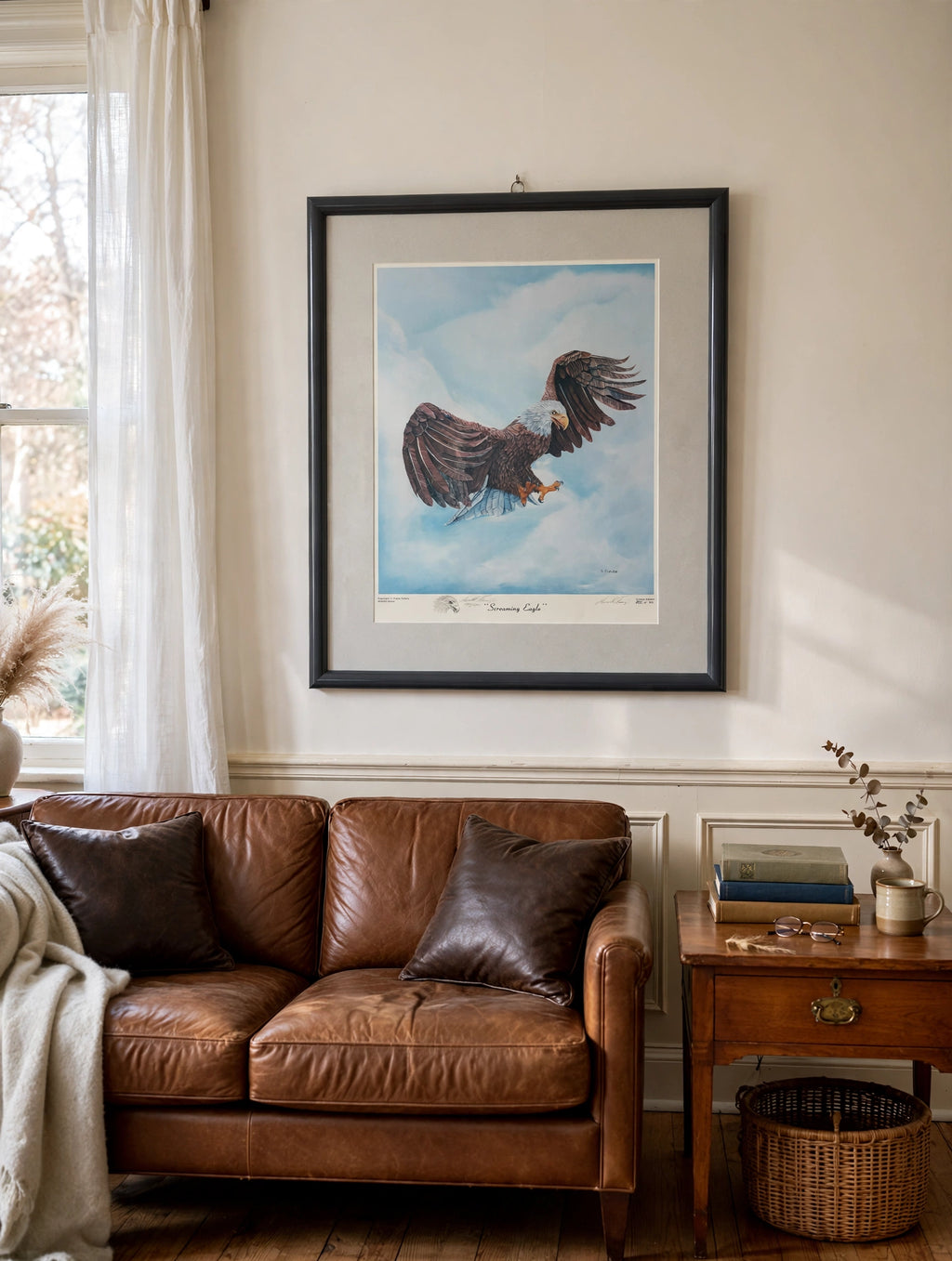 Styled lifestyle photo — the framed Screaming Eagle print hanging above a leather sofa in a vintage living room (display inspiration)