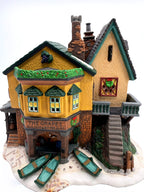 Department 56 Dickens' Village "The Grapes Inn" lighted porcelain building – front view showing the inn sign and three rowboats