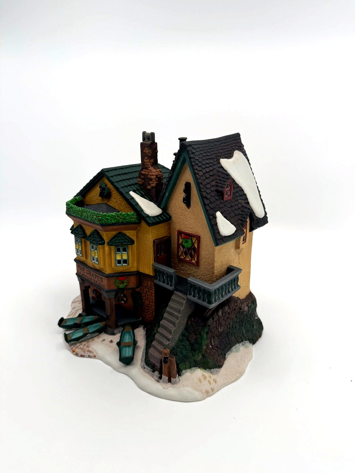 Department 56 Dickens' Village "The Grapes Inn" lighted porcelain building – three-quarter view showing the stone staircase, balcony and snow-dusted roofs