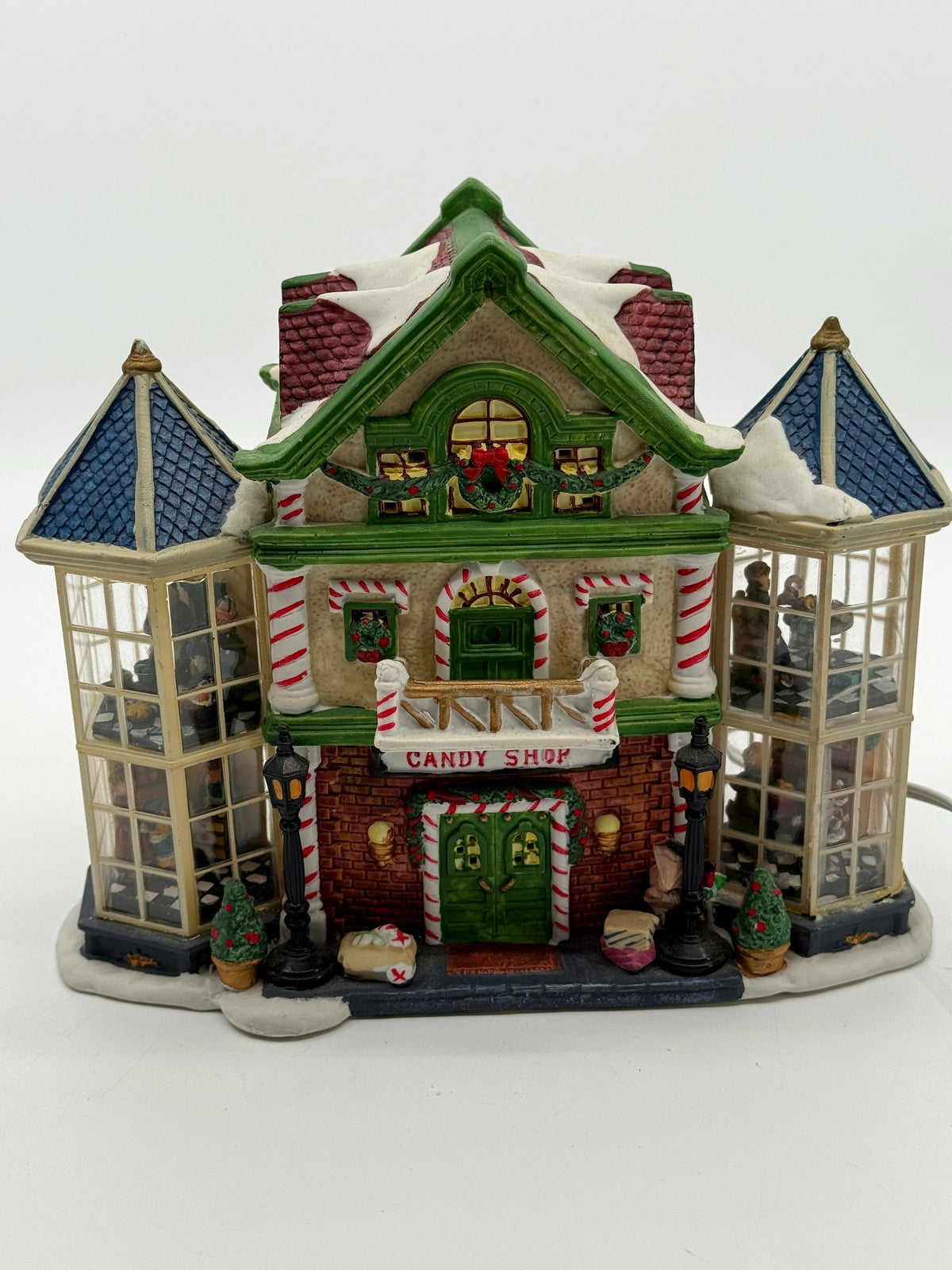 Lemax Carole Towne Child's Wonder Candy Shop lighted Christmas village building, front view — candy-cane columns, CANDY SHOP sign, and two glass bay towers with interior scenes