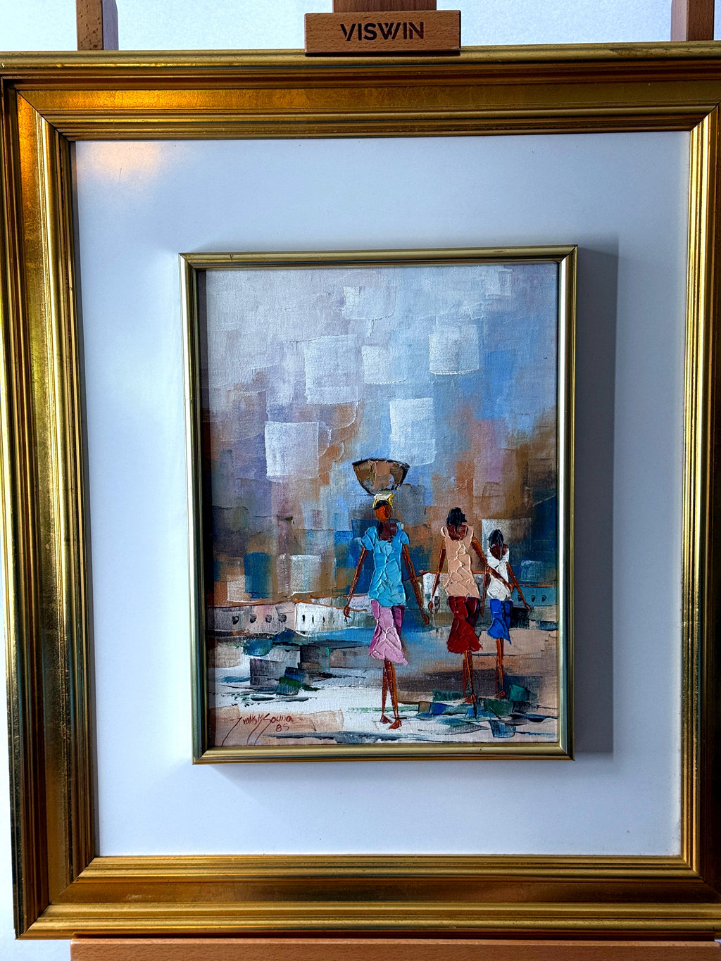 1985 signed impasto figural paintings on canvas — framed pair — the companion painting in its gilt frame — a woman balancing a bowl on her head, walking with two children