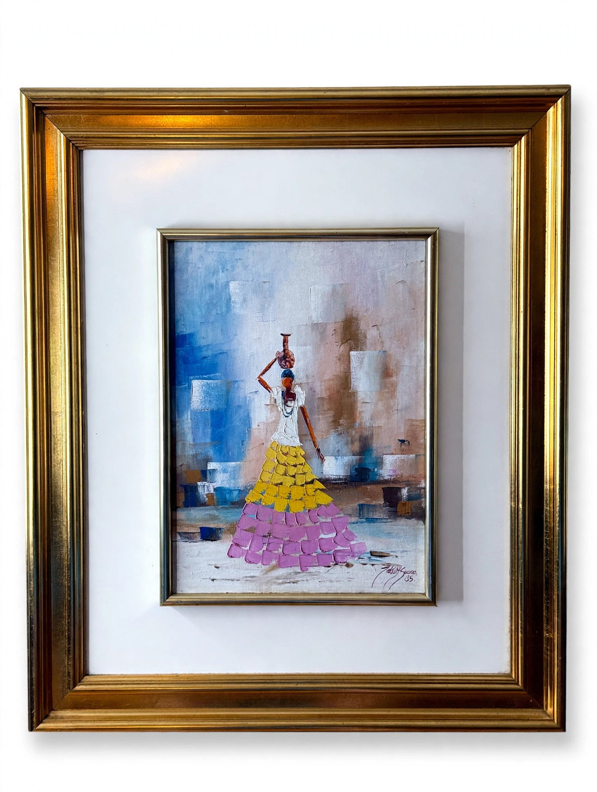 1985 signed impasto figural paintings on canvas — framed pair — the water-carrier painting in its gilt frame on an easel — a woman in a yellow and pink tiered skirt balancing a vessel on her head