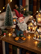 Julenisse on a bookshelf with illuminated Christmas village houses - styled display scene