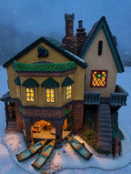 Styled lifestyle photo: The Grapes Inn lit at dusk, windows glowing in falling snow - display inspiration